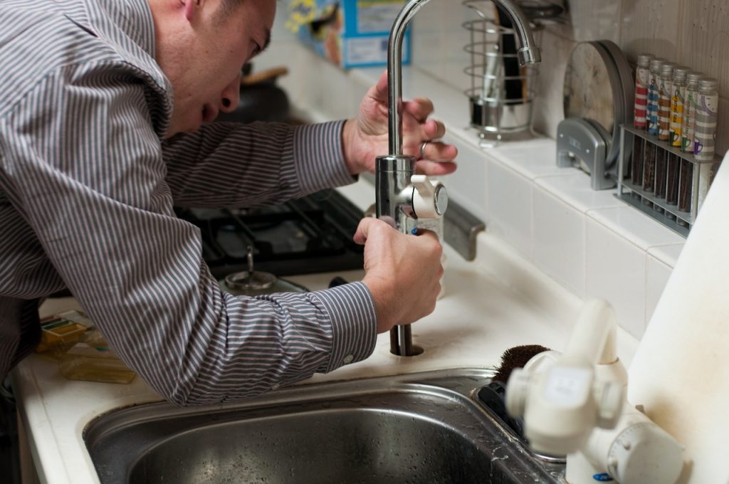 A plumber fixing a tap.